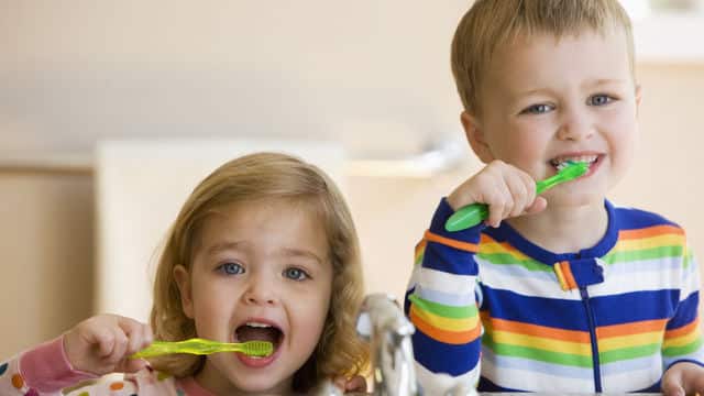 Toddlers brushing and flossing their teeth